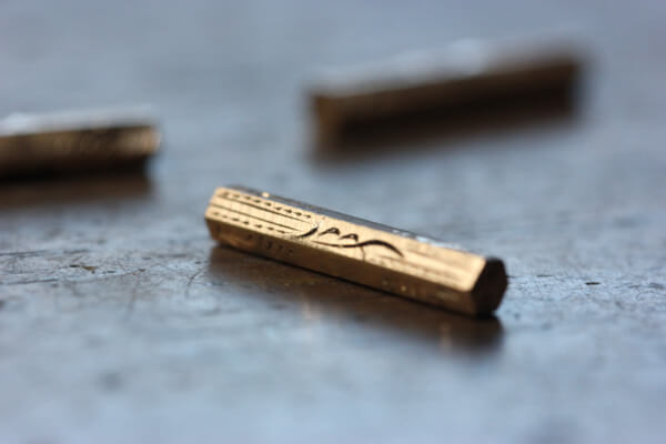 handgravyr utförd på guldstav